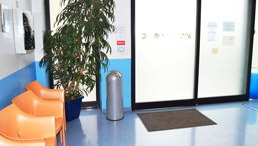 Una sala d'attesa con sedie e un bidone della spazzatura