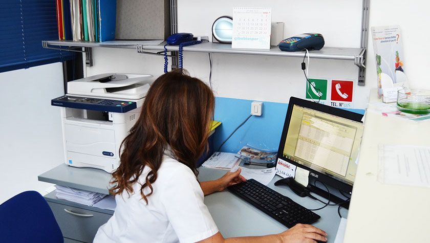 Una donna è seduta alla scrivania davanti a un computer.