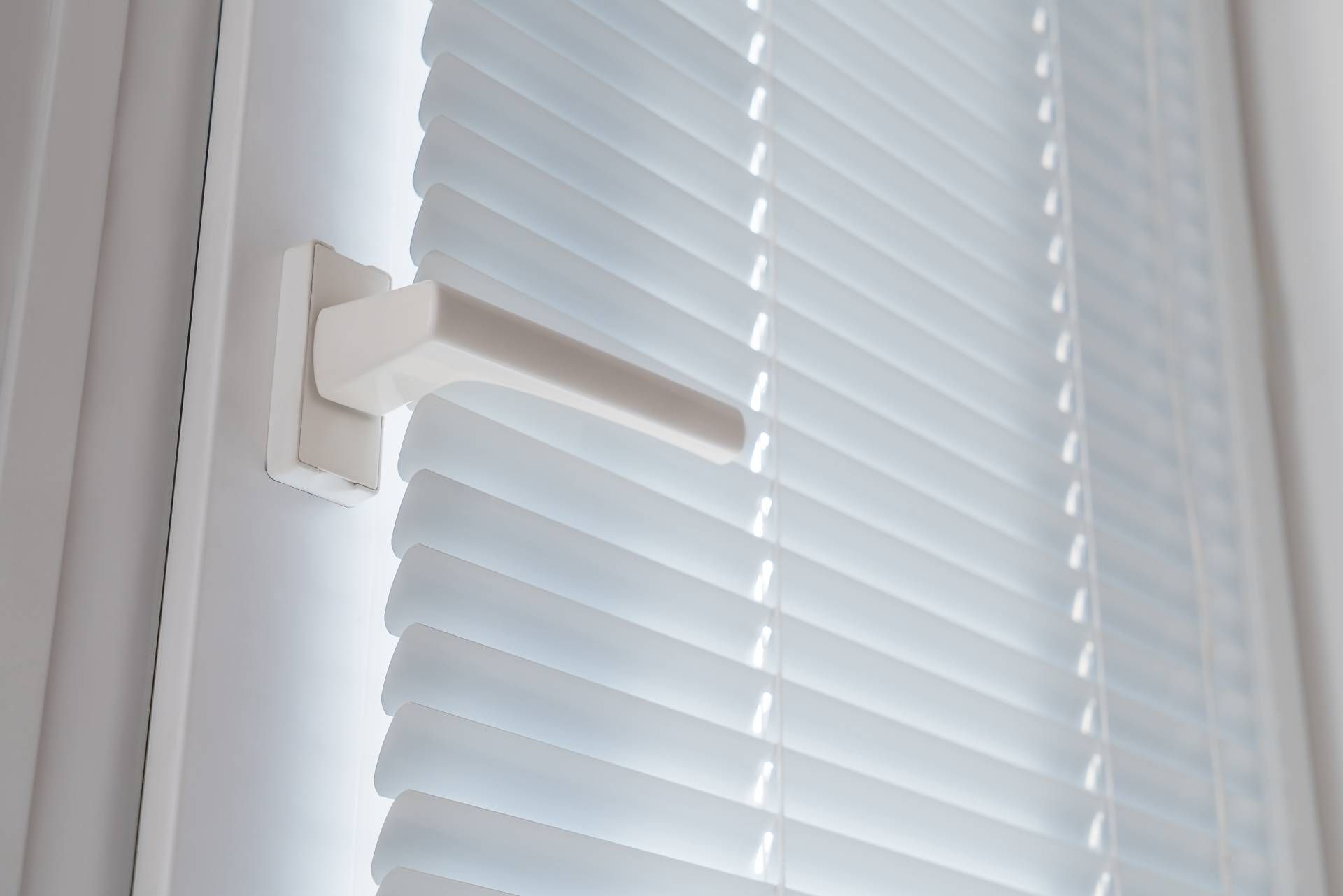 White door with handle covered by white window blinds near Frederick, MD.