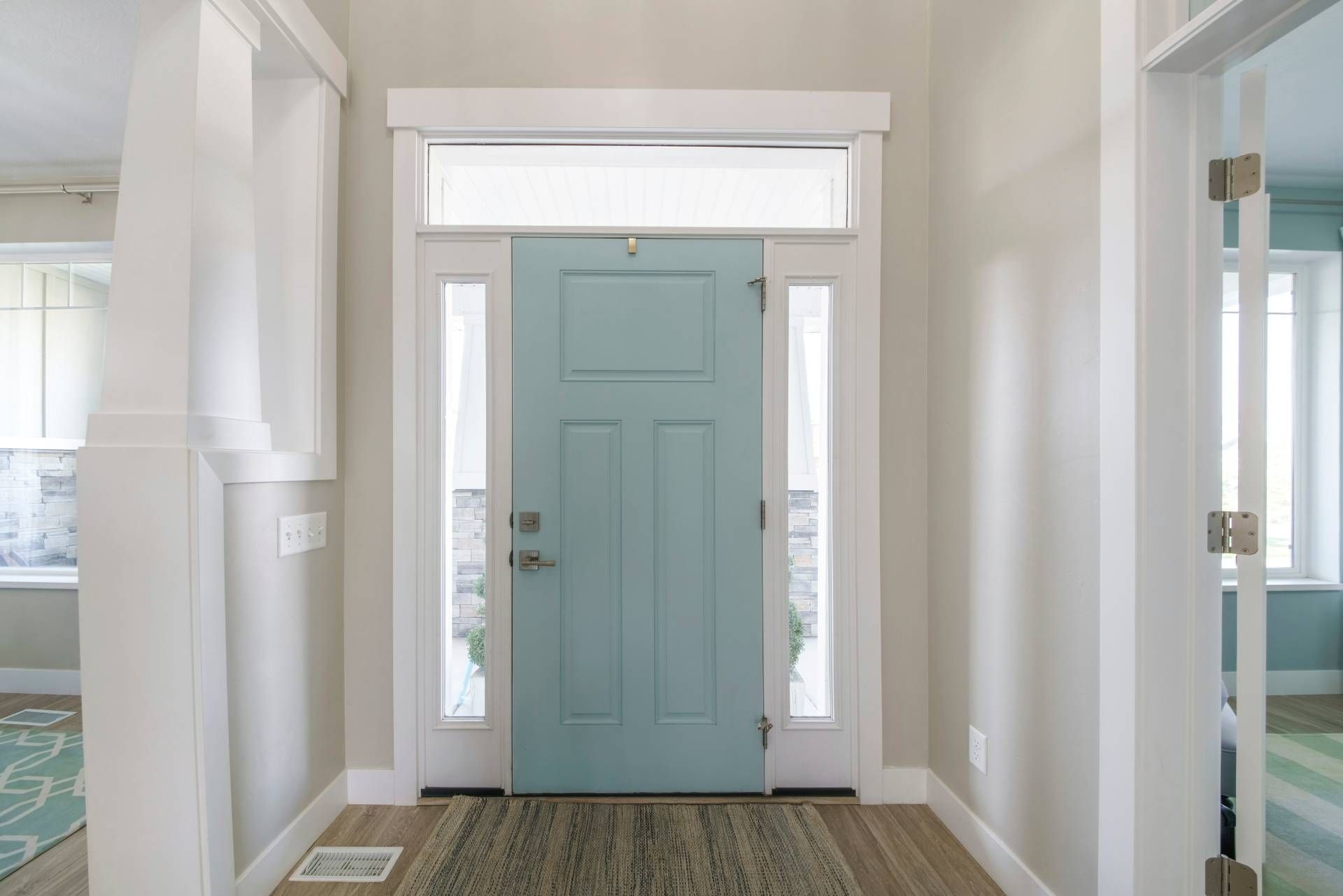 Modern home with blue front door and two sidelight windows in an entryway