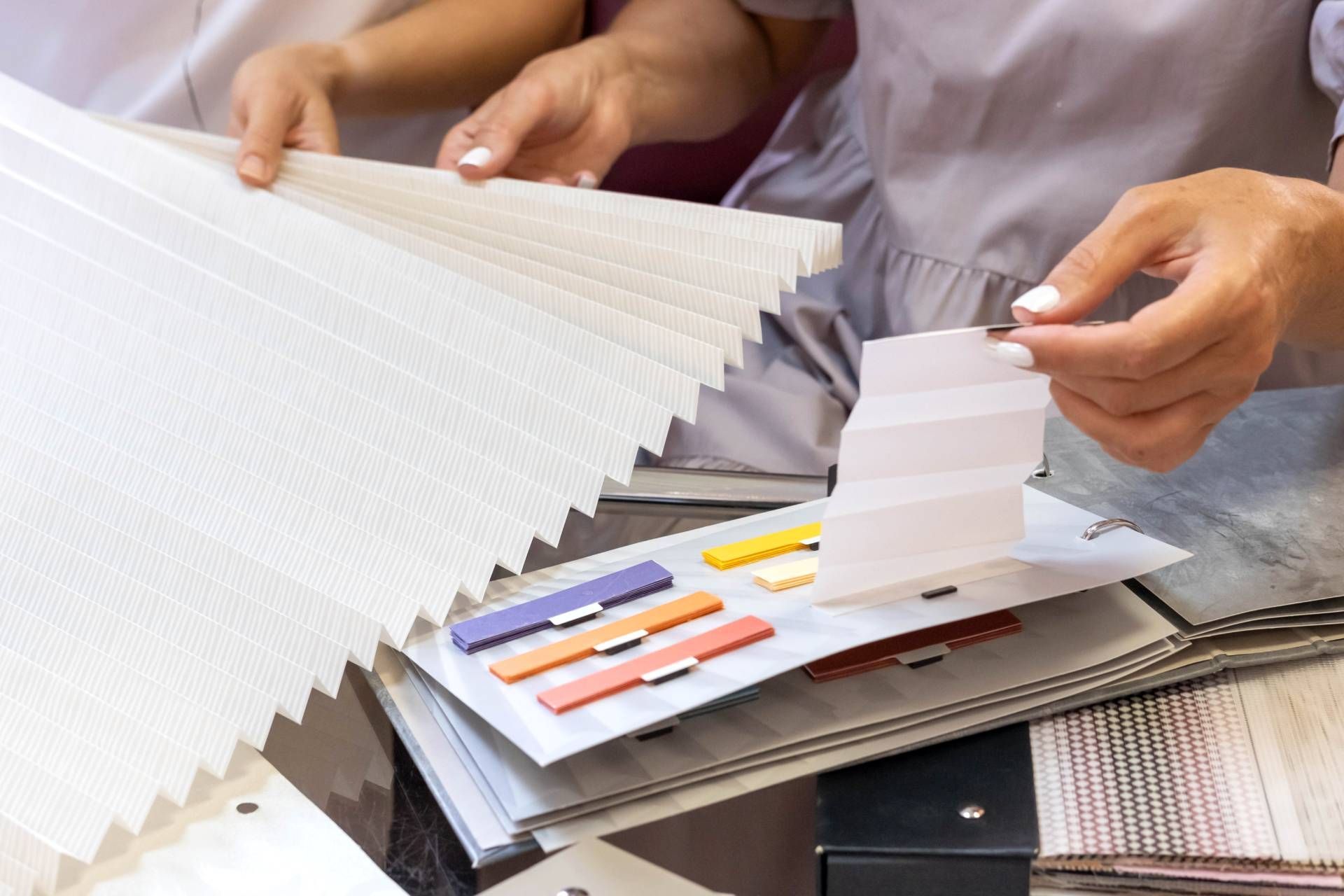 Two people looking at window treatment samples in a showroom near Frederick, MD