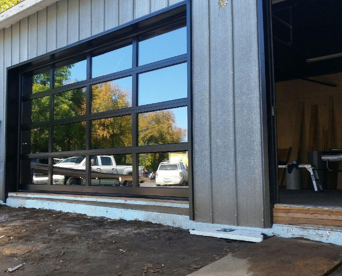 Une porte de garage avec beaucoup de fenêtres et un camion garé devant.