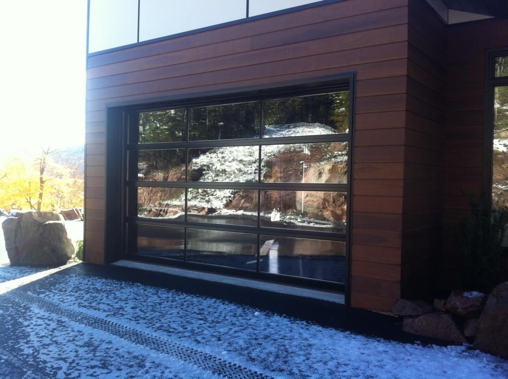 Une grande porte de garage avec beaucoup de fenêtres sur une maison