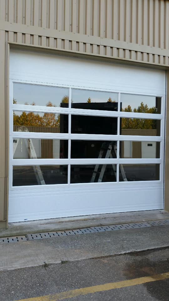 Une porte de garage blanche avec beaucoup de fenêtres