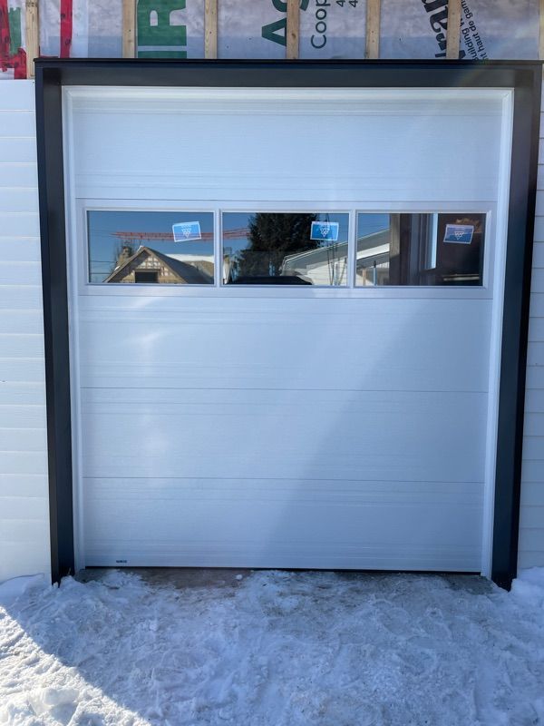 Une porte de garage blanche avec une fenêtre à l'intérieur