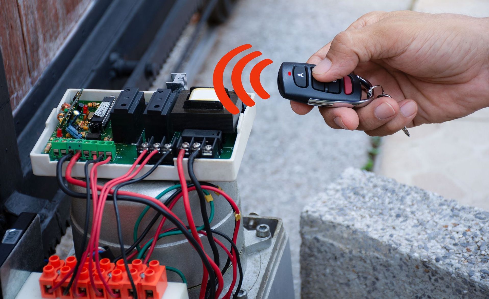 Une personne utilise une télécommande pour ouvrir un portail.