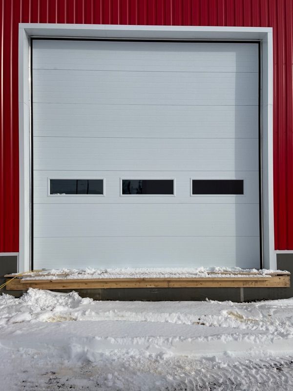 Un bâtiment rouge avec une porte de garage blanche