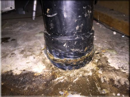 A black pipe is sitting on top of a concrete floor.