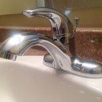 A close up of a bathroom sink with a chrome faucet.