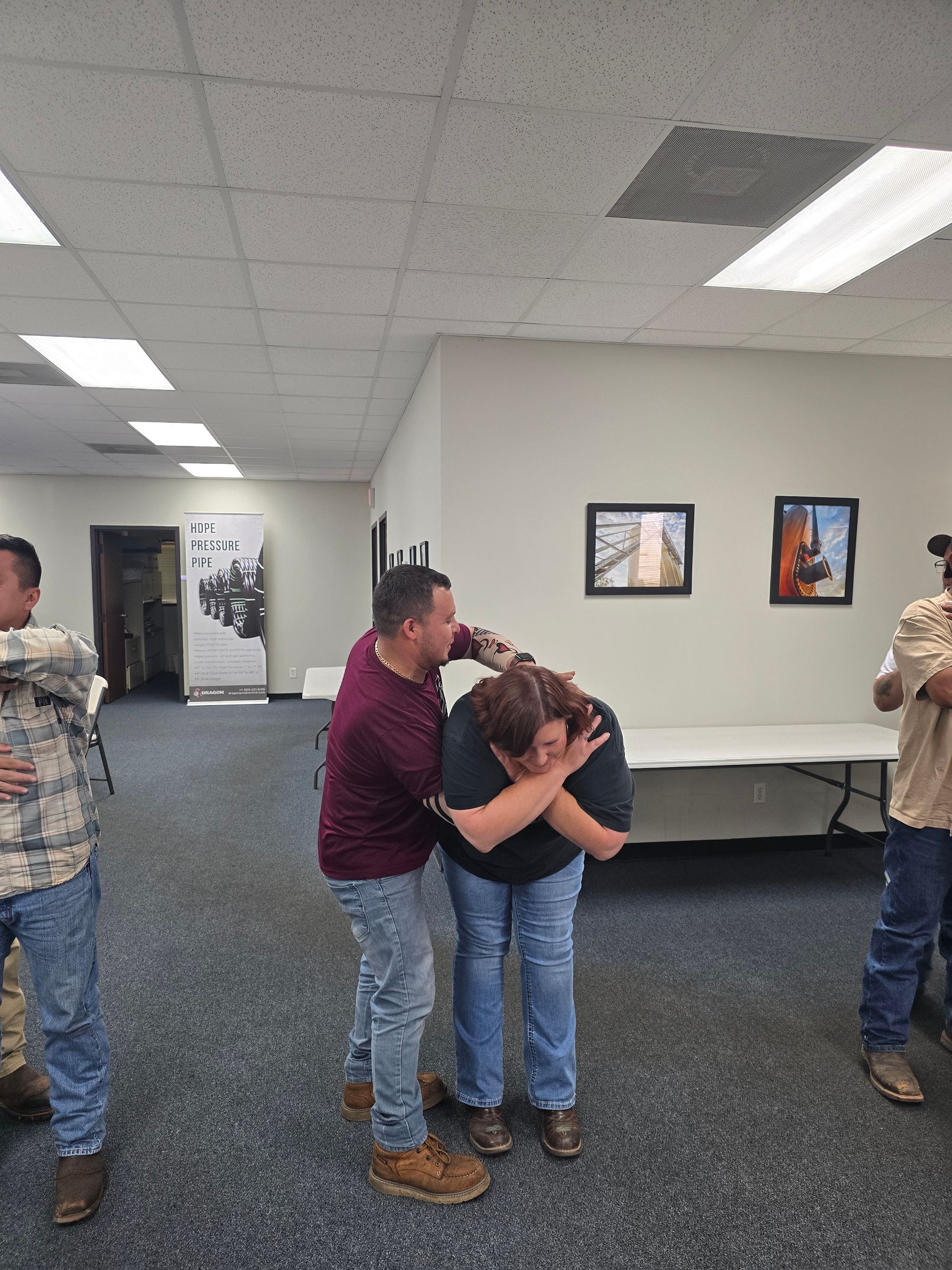 Man demonstrating self-defense technique on a person in an office setting. Other people observe.