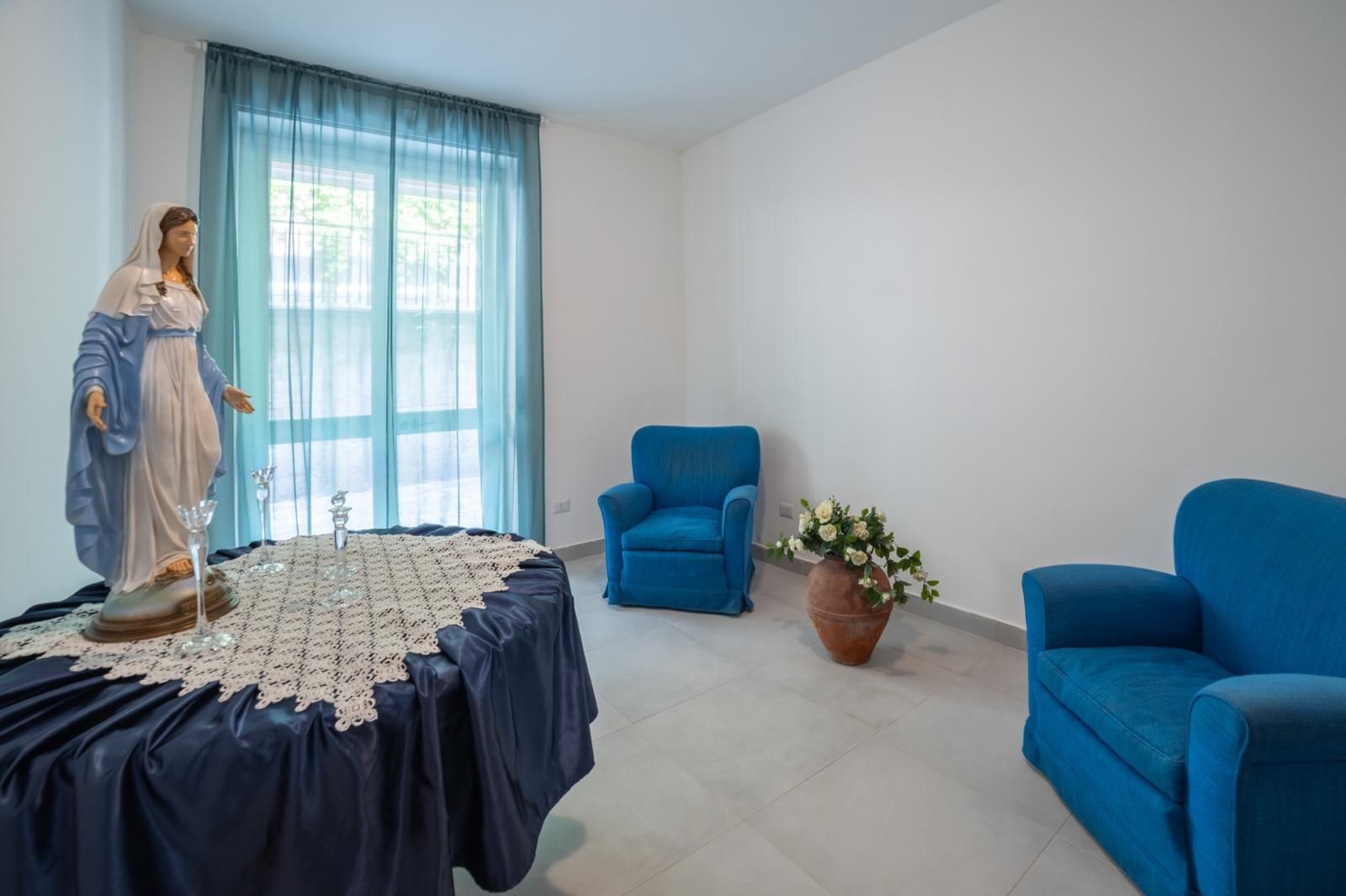 Persone sedute su banchi di legno all'interno di una chiesa, rivolte verso una croce dorata con candele accese su un altare.