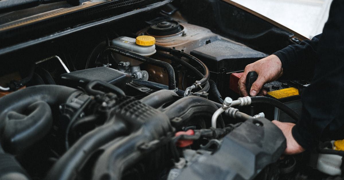 A person is working on the engine of a car. | Bartel's Auto Clinic