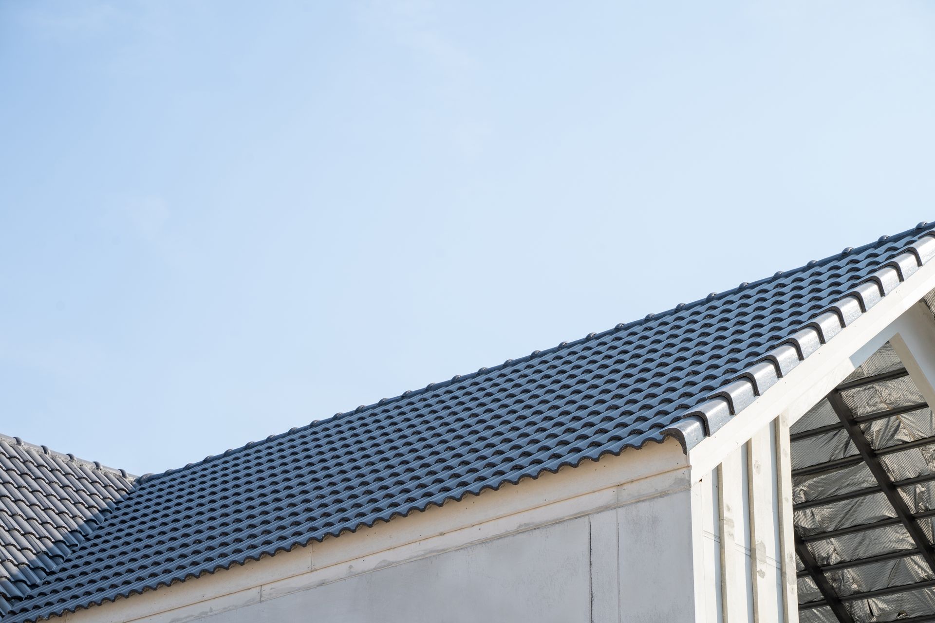 Blue tiled roof against a clear blue sky, part of a building.