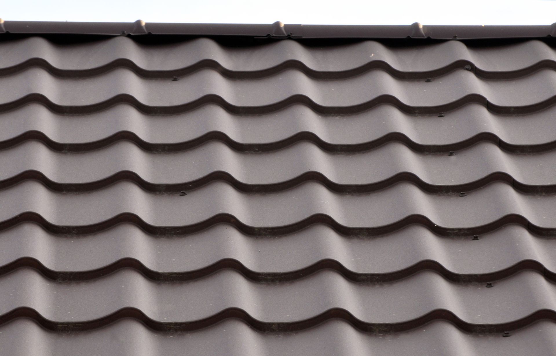 Brown metal roof tiles with a wave pattern.