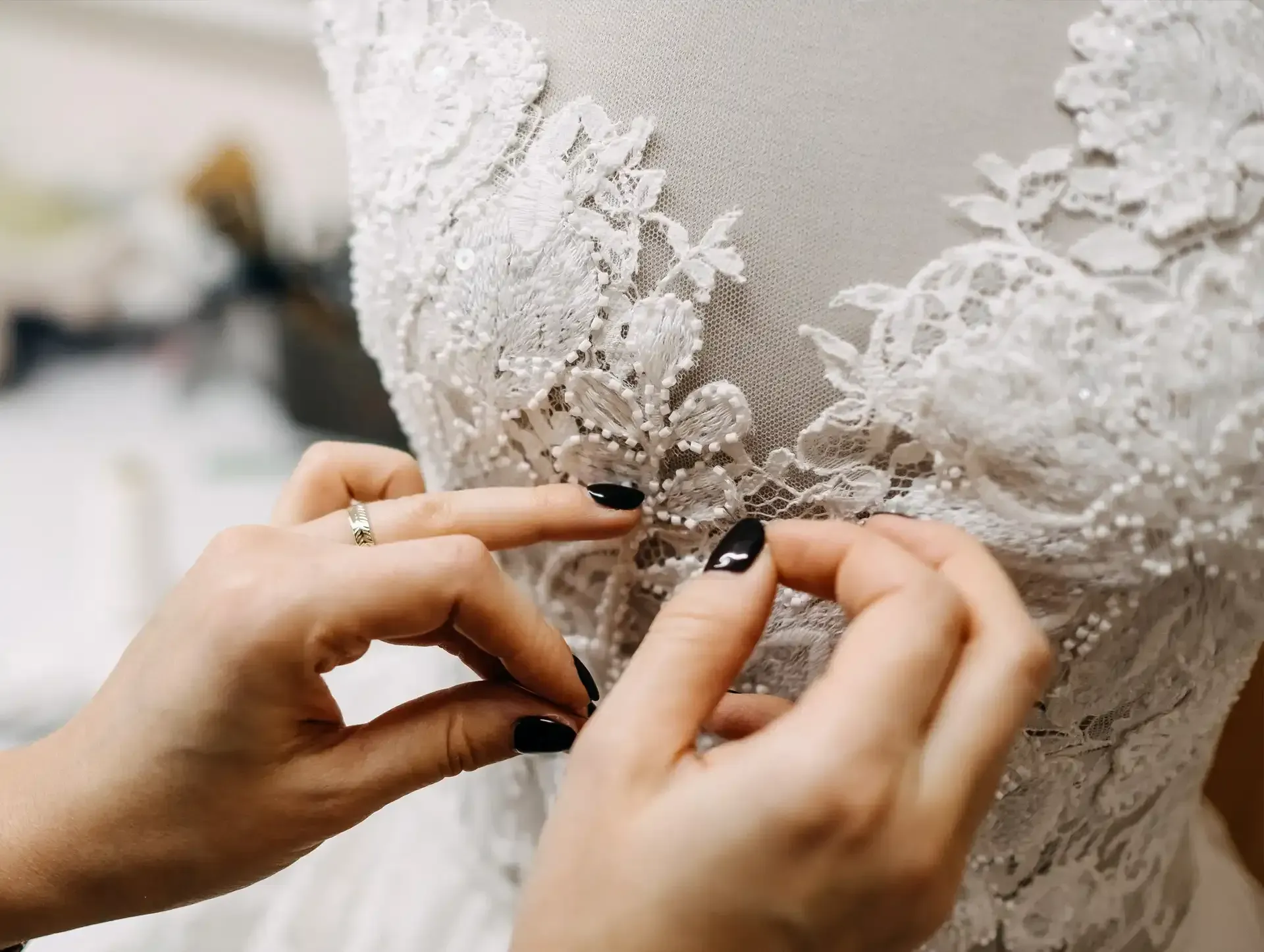 A Tailor is fixing a wedding dress on a mannequin at Luxury Tailors by Monica.