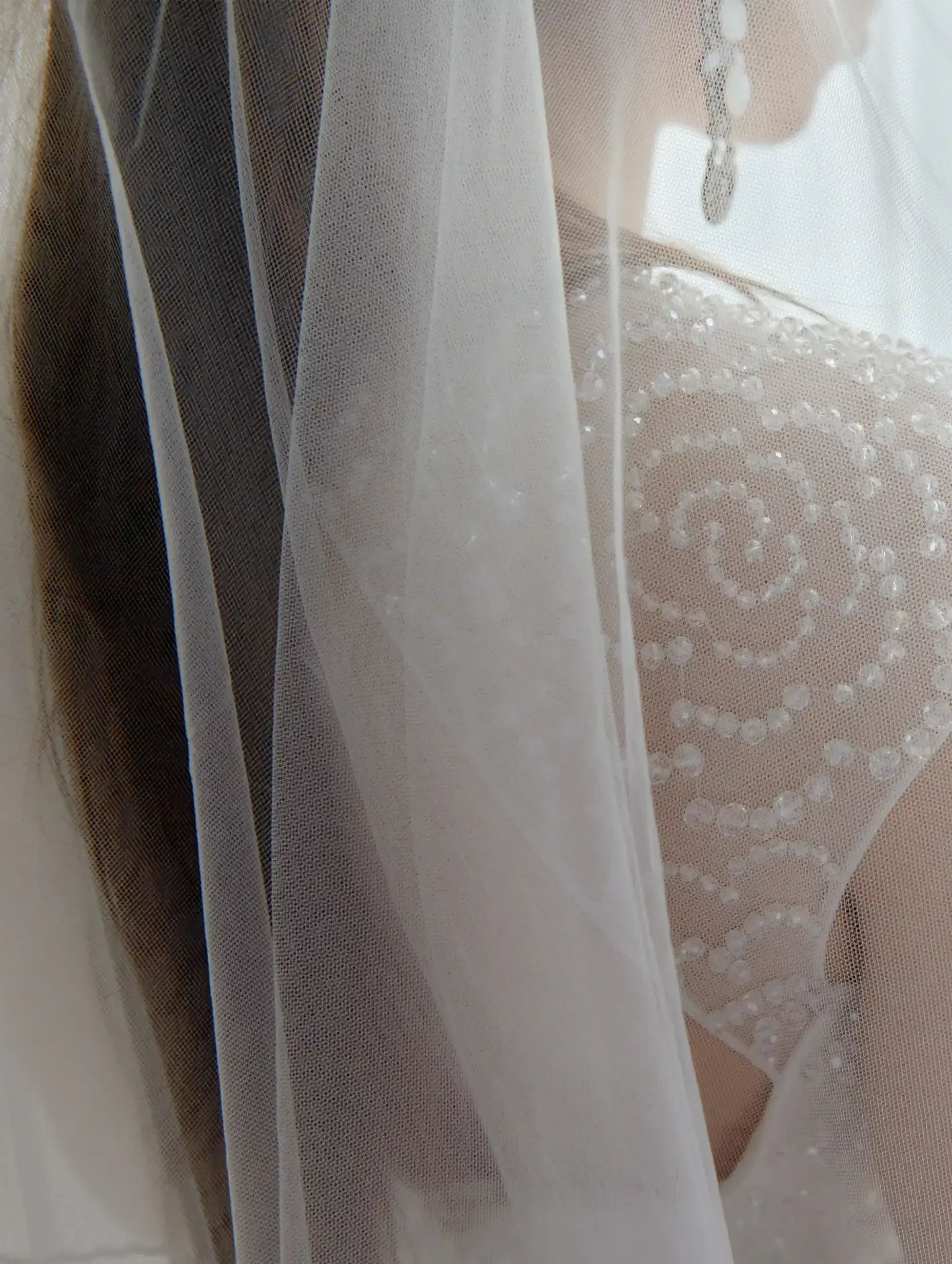 A close up of a woman wearing a wedding dress and veil.