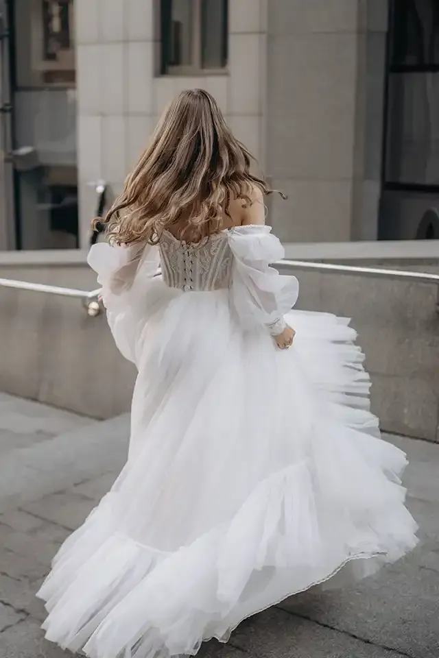 A woman in a white dress is walking down the street.