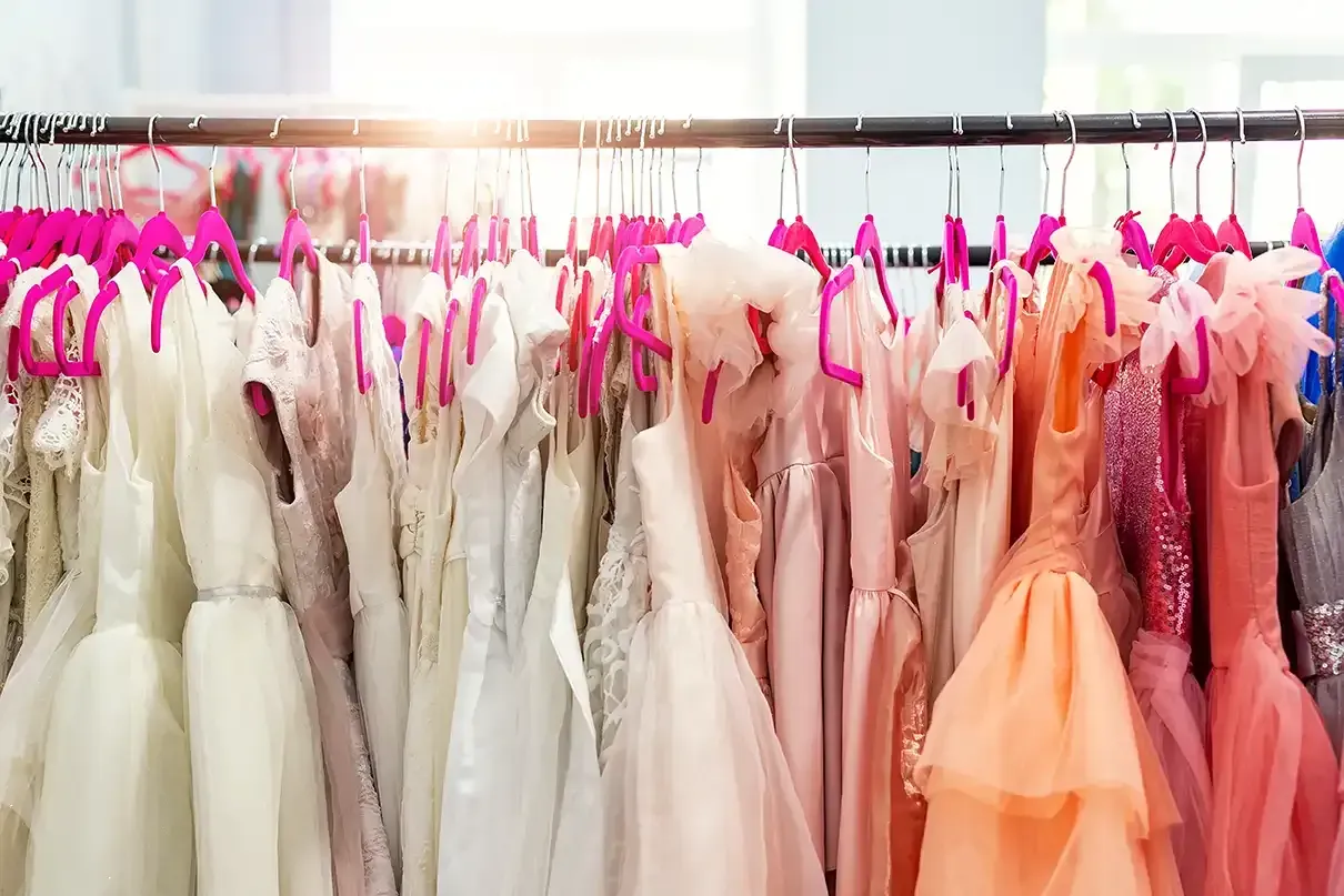 A row of dresses hanging on a rack in a store.