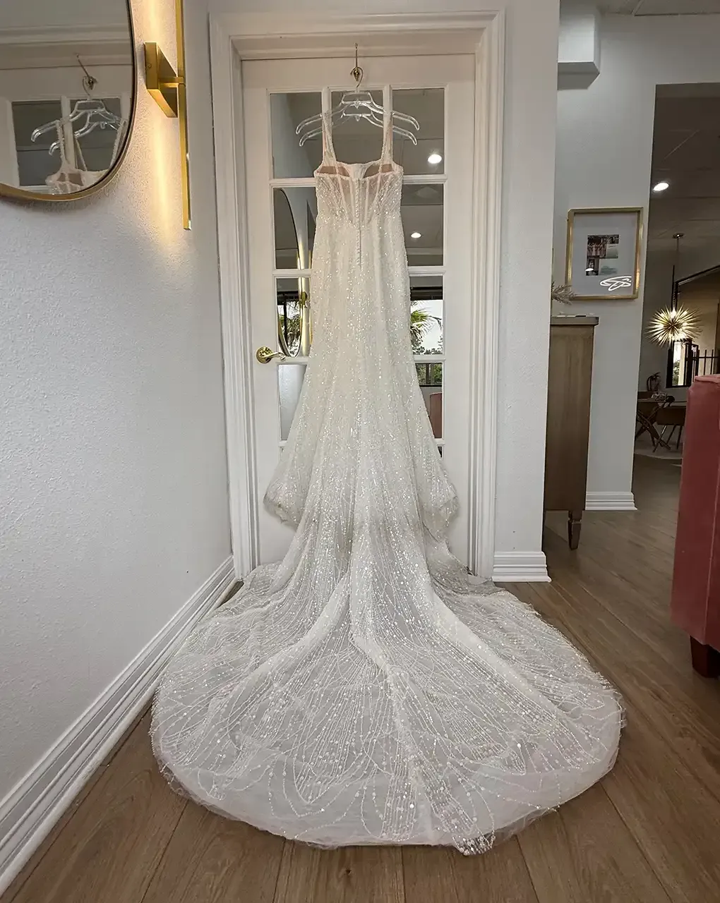 A close up of a white lace wedding dress with buttons.