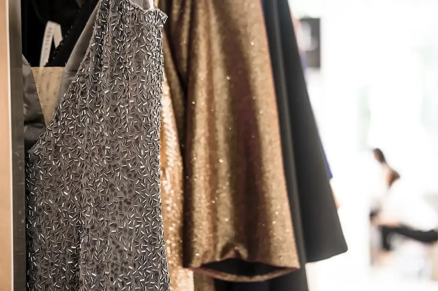A close up of a closet filled with clothes hanging on a rack.