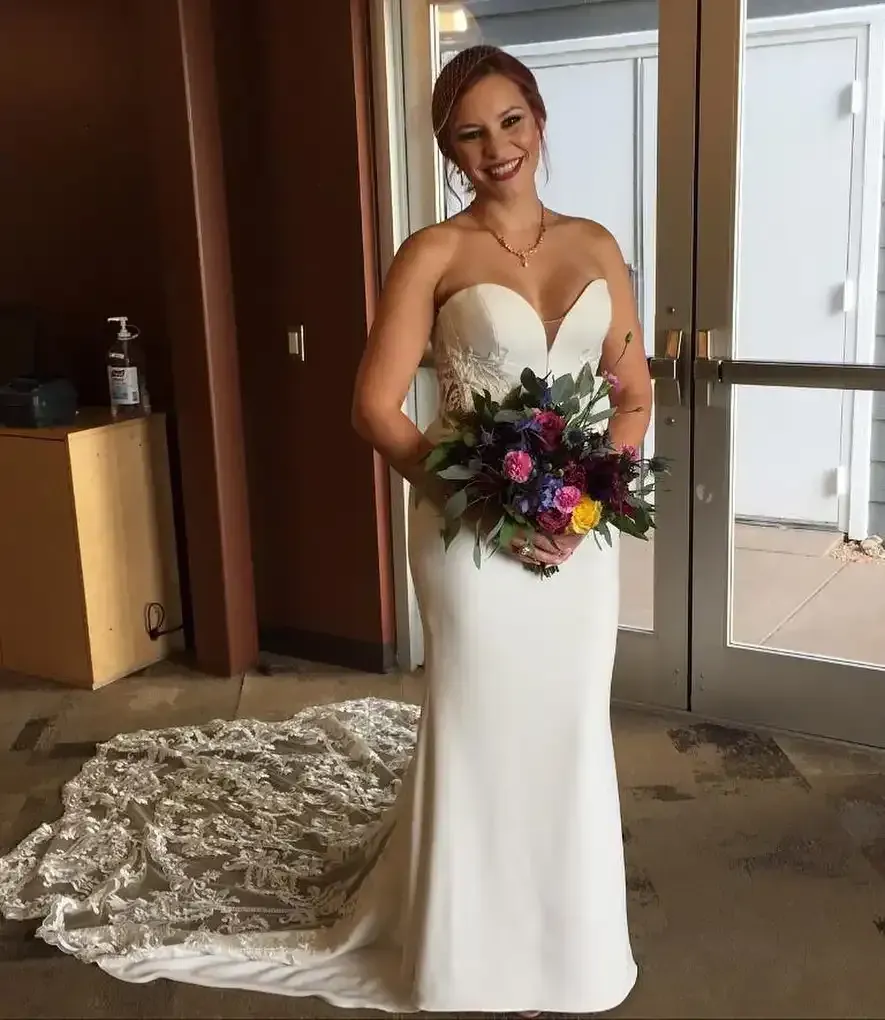 A woman in a wedding dress is holding a bouquet of flowers