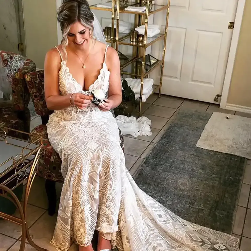 A woman in a wedding dress is sitting on a chair in a room.