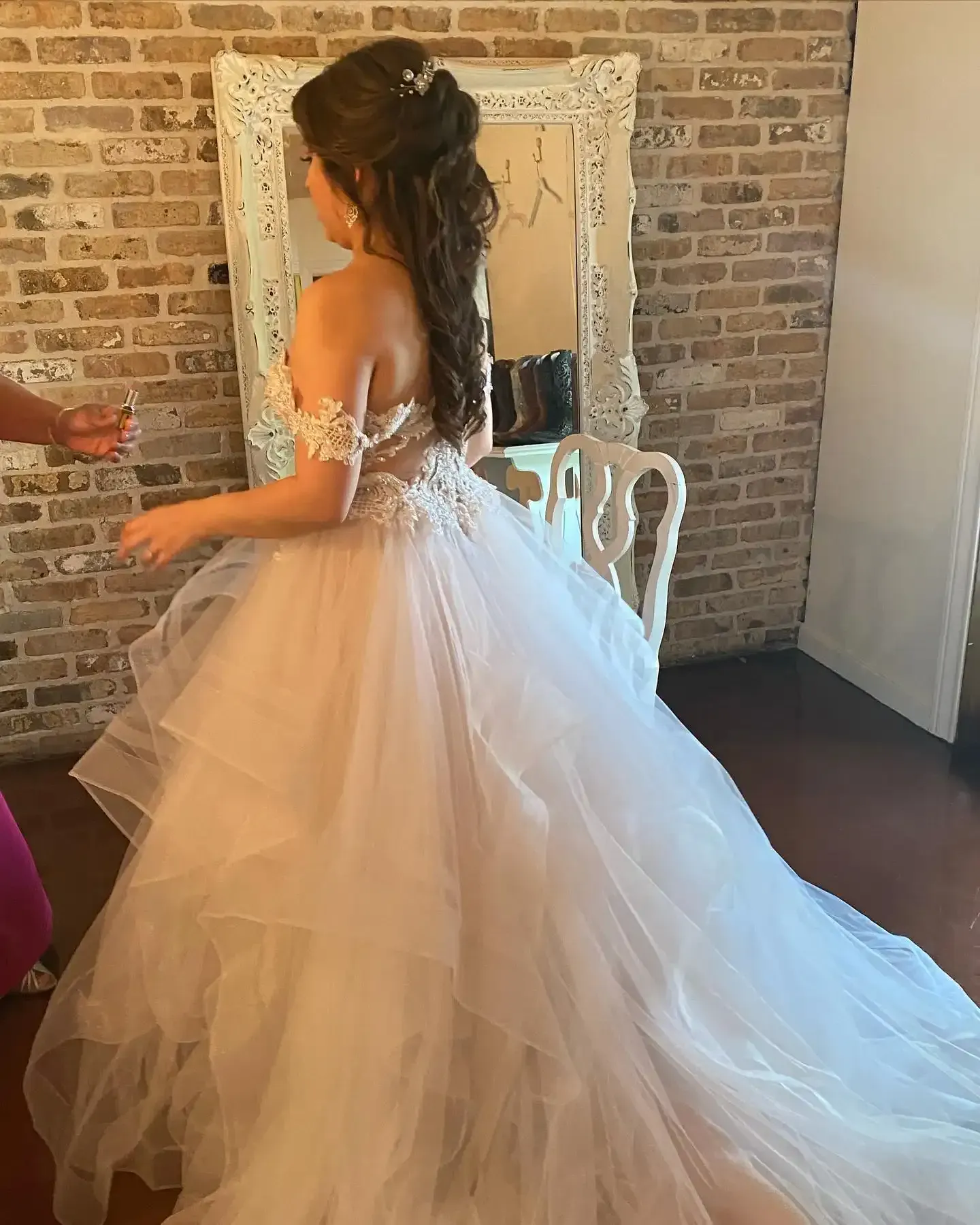 A woman in a wedding dress is standing in front of a mirror.