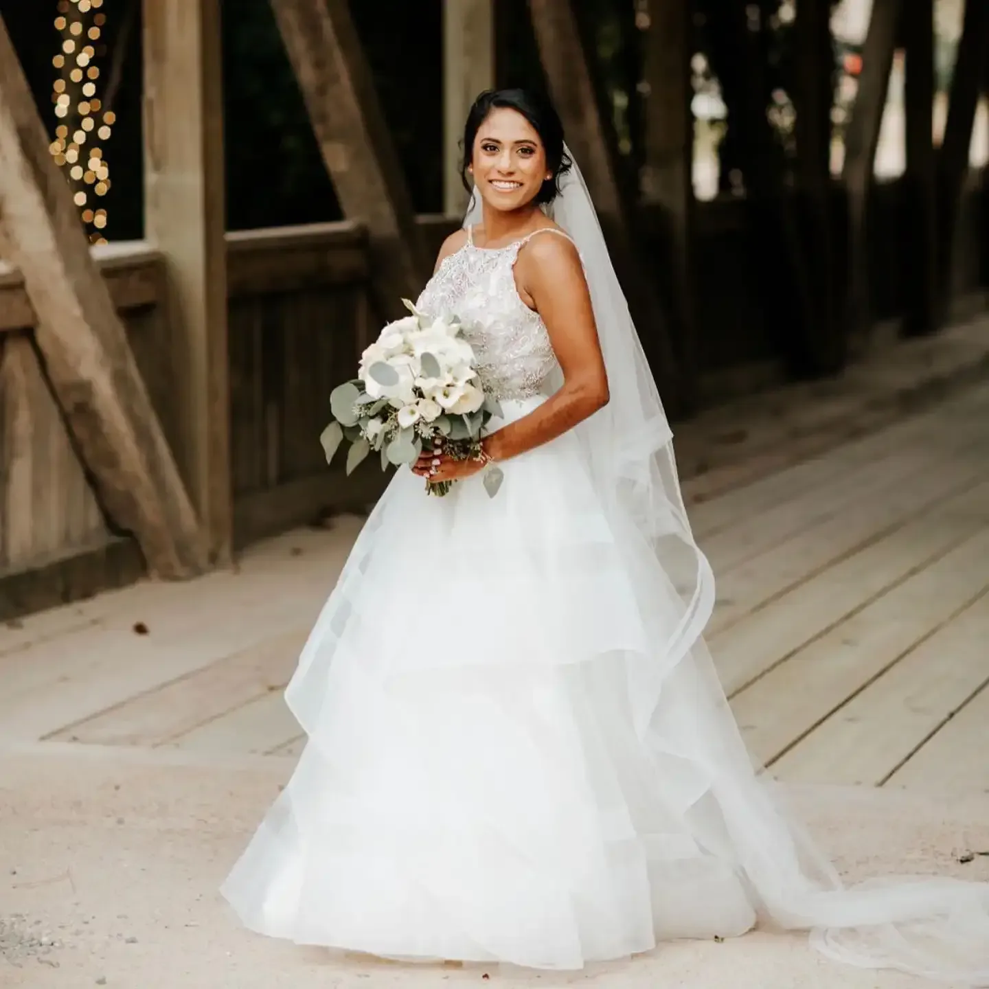 A bride in a white wedding dress is holding a bouquet of flowers.