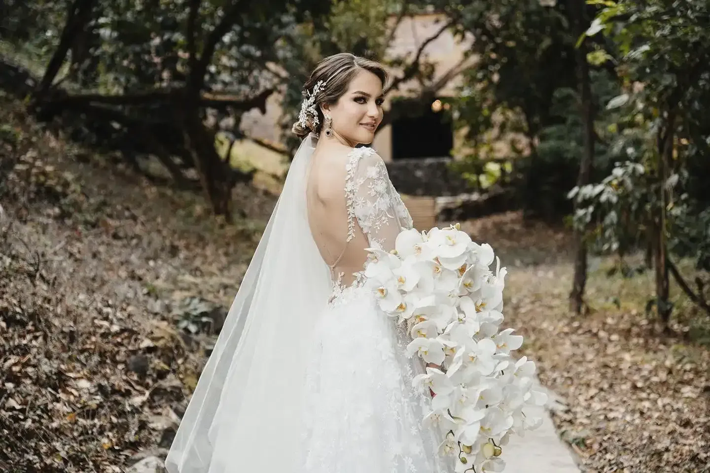 A bride in a wedding dress is holding a bouquet of white flowers.