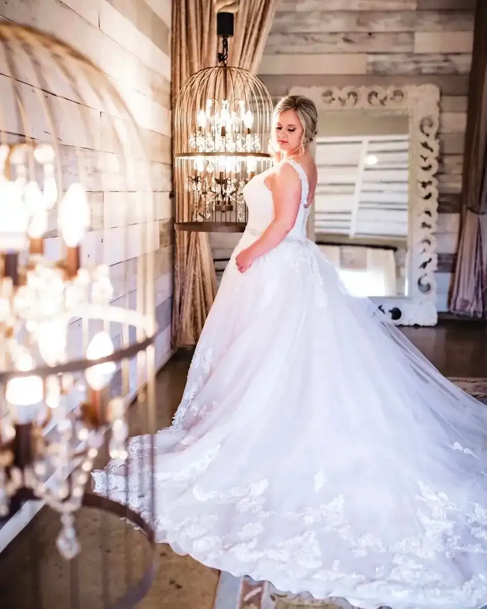 A woman in a wedding dress is standing in front of a mirror.