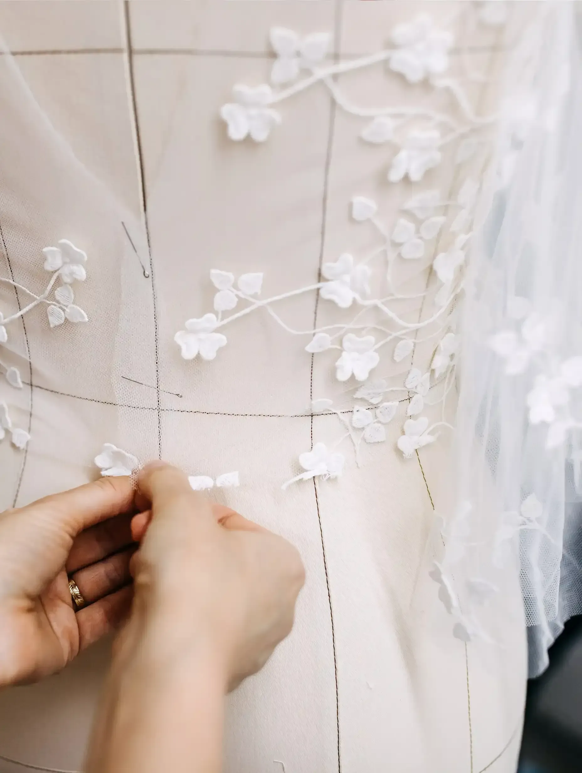 A person is working on a dress on a mannequin.