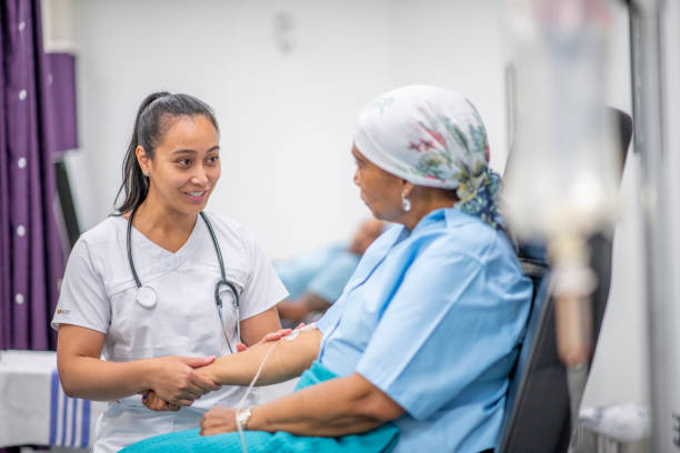 A nurse is talking to a patient in a hospital room.