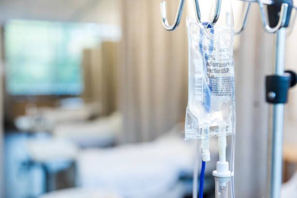 An iv bag is hanging from a hook in a hospital room.
