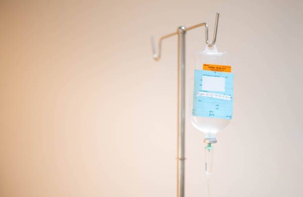 An iv bag is hanging from a pole in a hospital room.