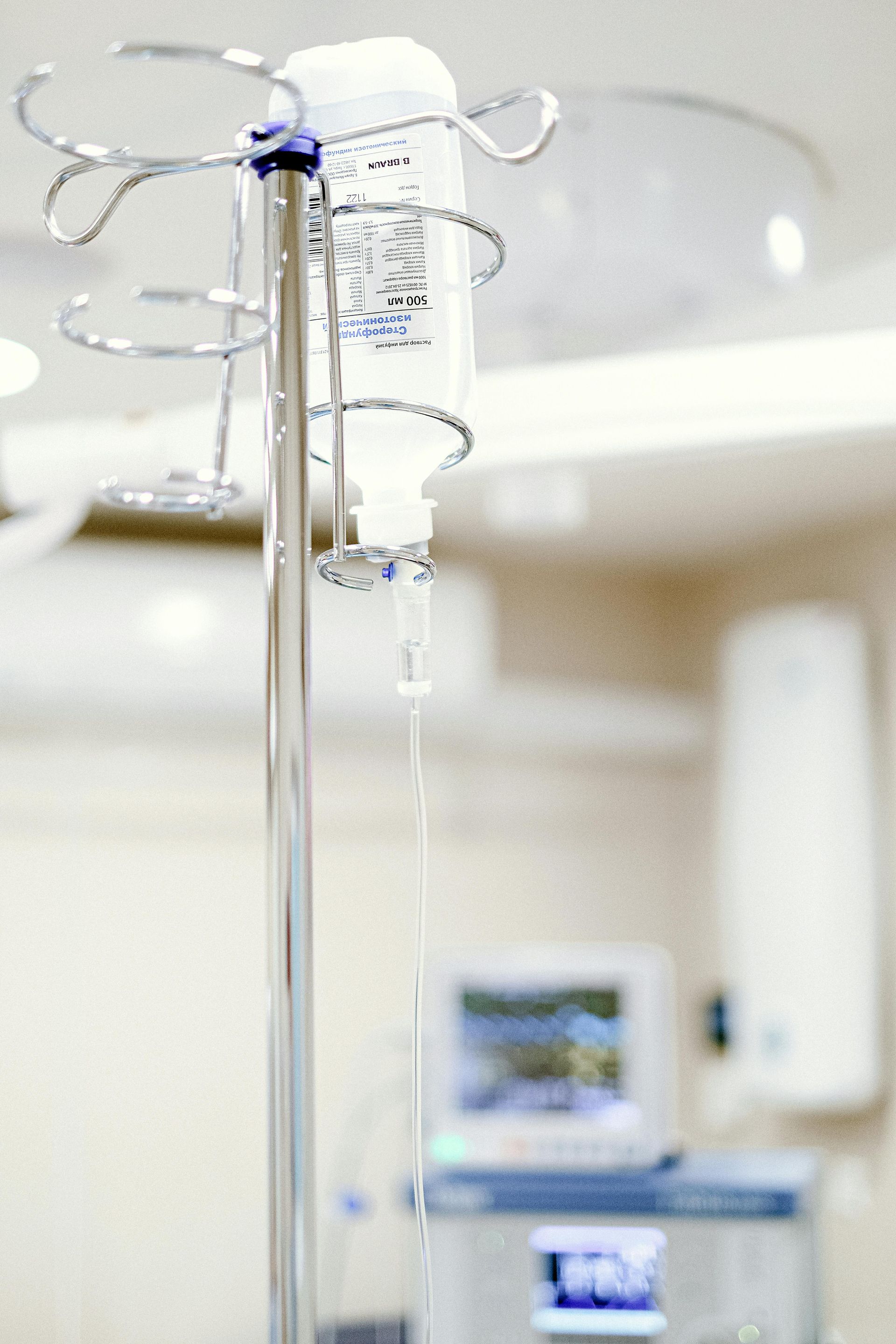 IV drip bag hanging from a silver stand in a medical setting.