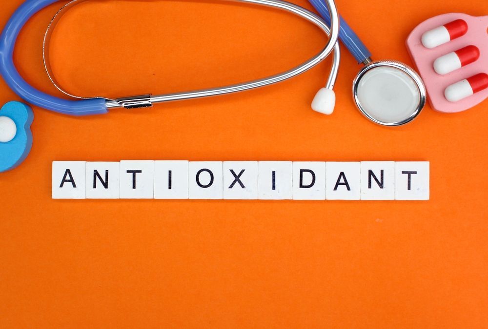The word antioxidant is written on a orange background with a stethoscope and pills.