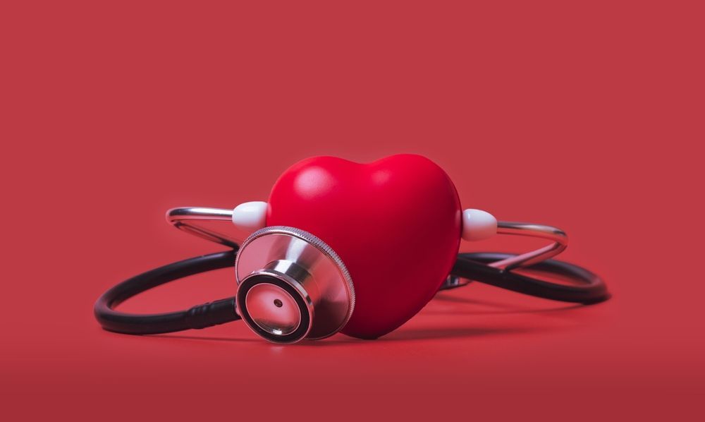 A red heart with a stethoscope around it on a red background.