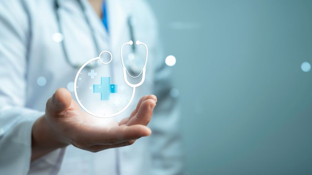 A doctor is holding a stethoscope and a cross in her hands.