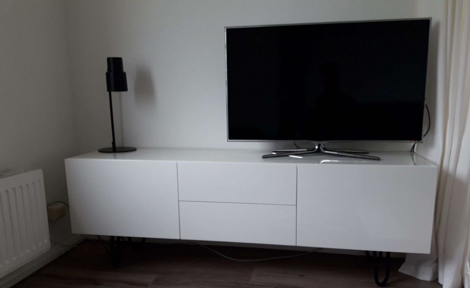 Op maat gemaakt hoogglans wit TV meubel met greeploze en zachtsluitende deuren en lades.