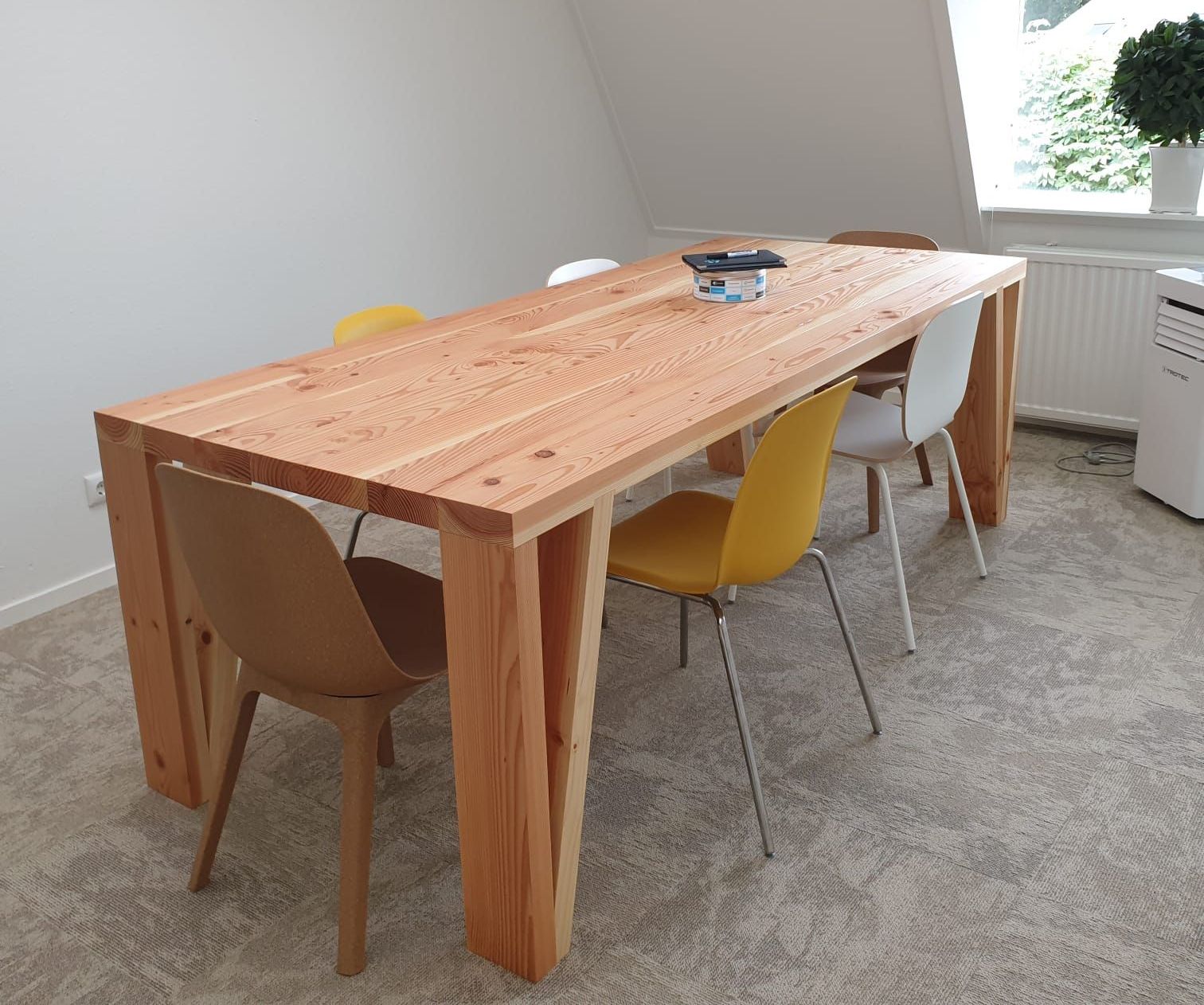 Robuuste vergadertafel en twee extra werkpekken in een kantooromgeving.