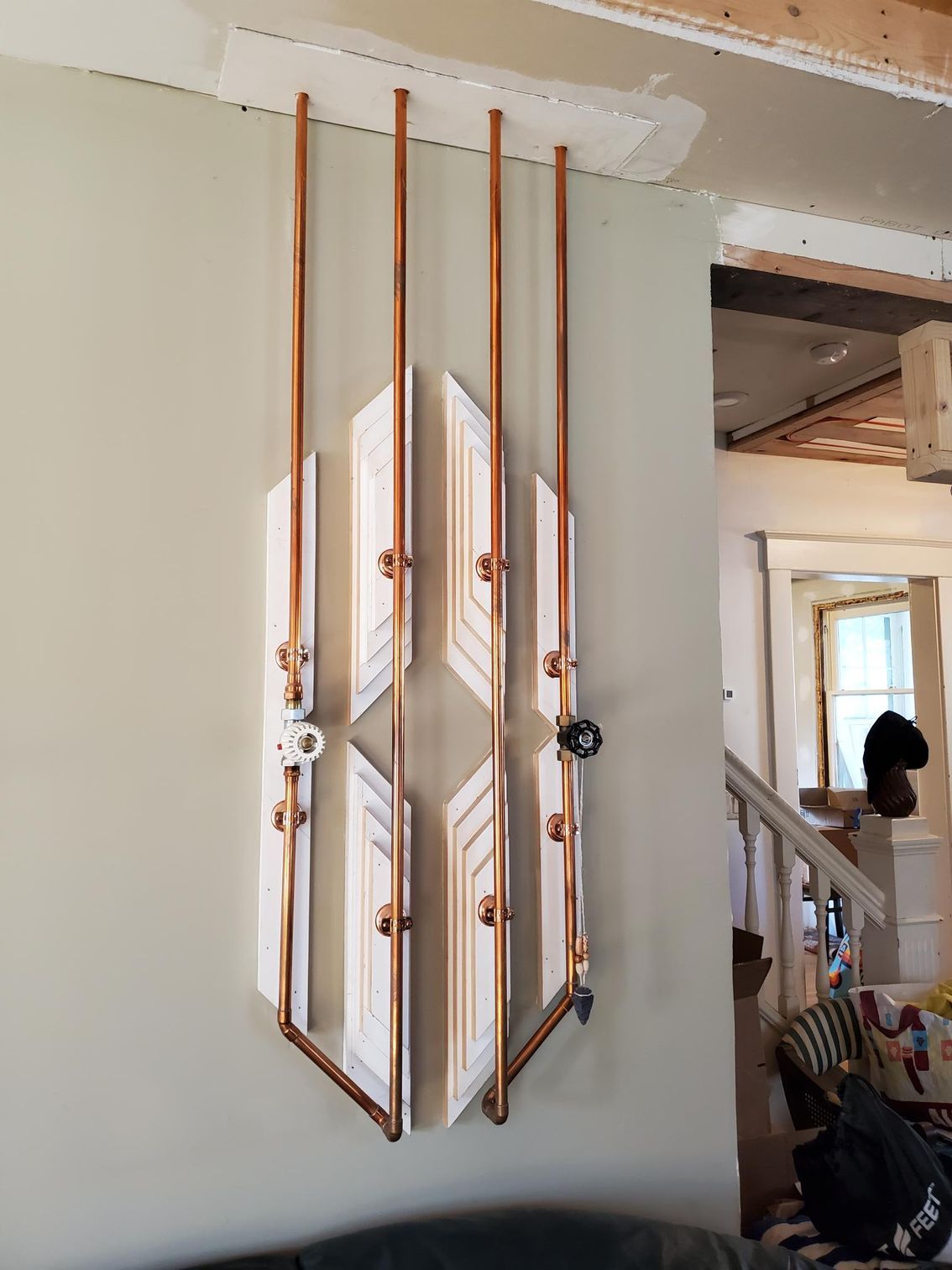 A copper pipe hanging from the ceiling in a living room