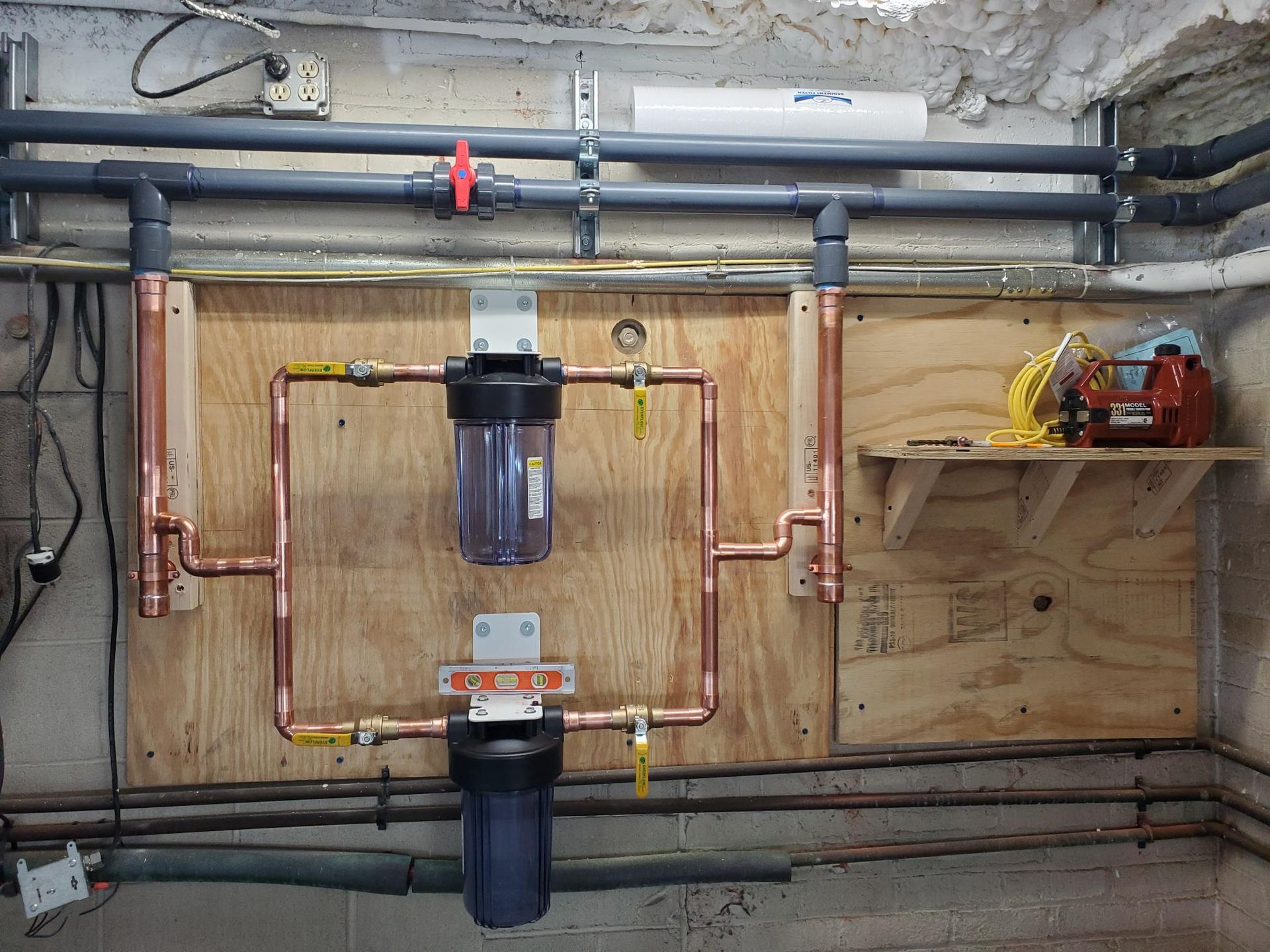 A plumbing system is hanging on a wooden wall.