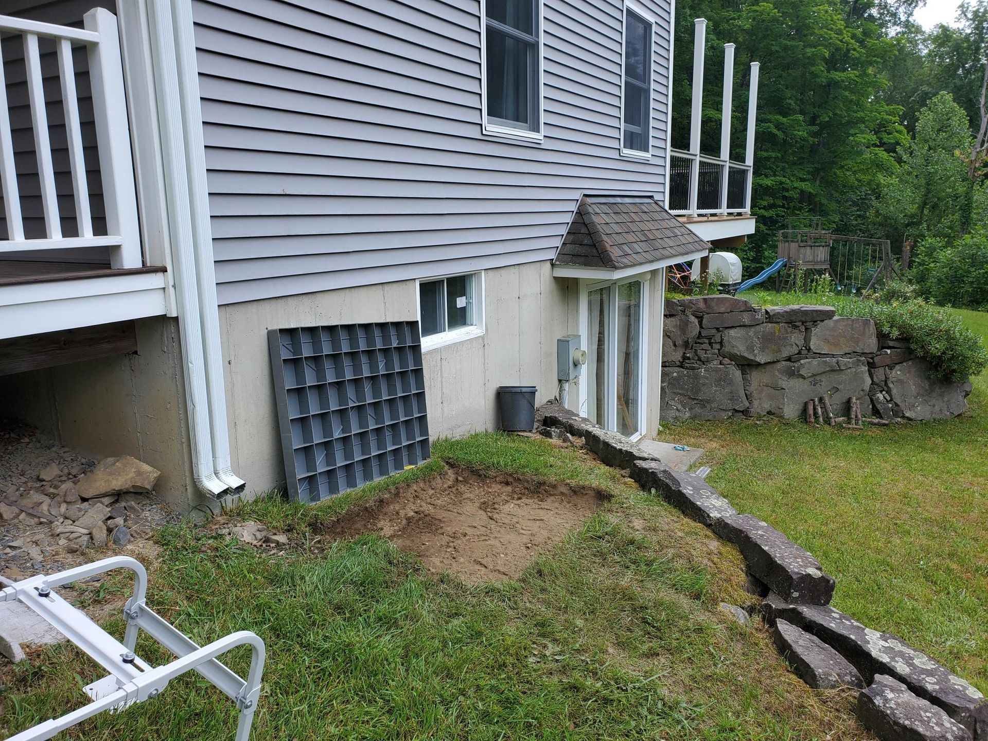 There is a hole in the ground in front of a house.