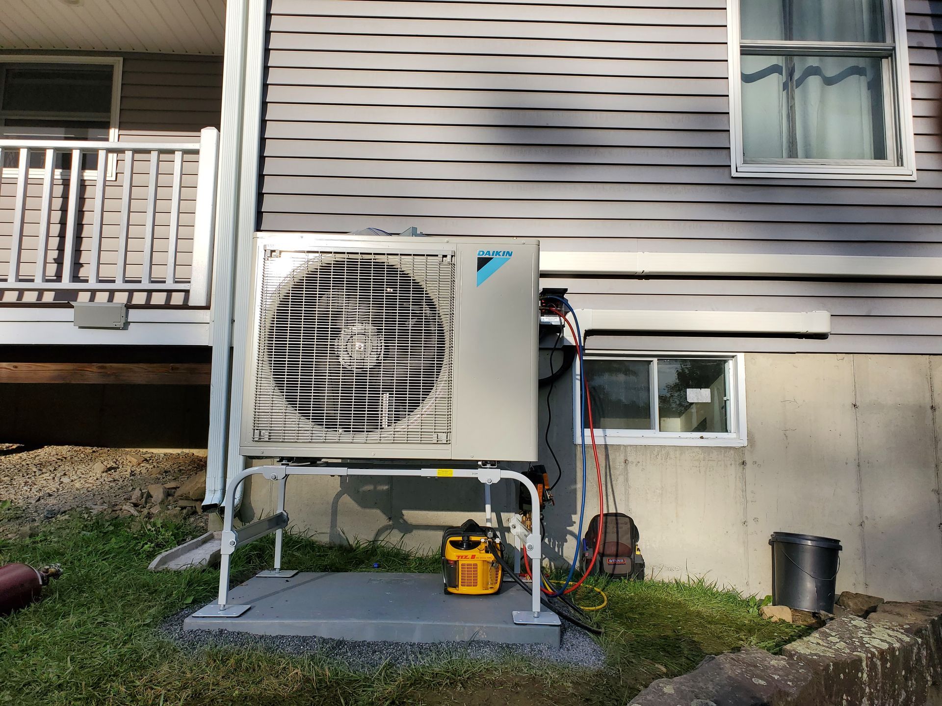 A large air conditioner is installed on the side of a house.