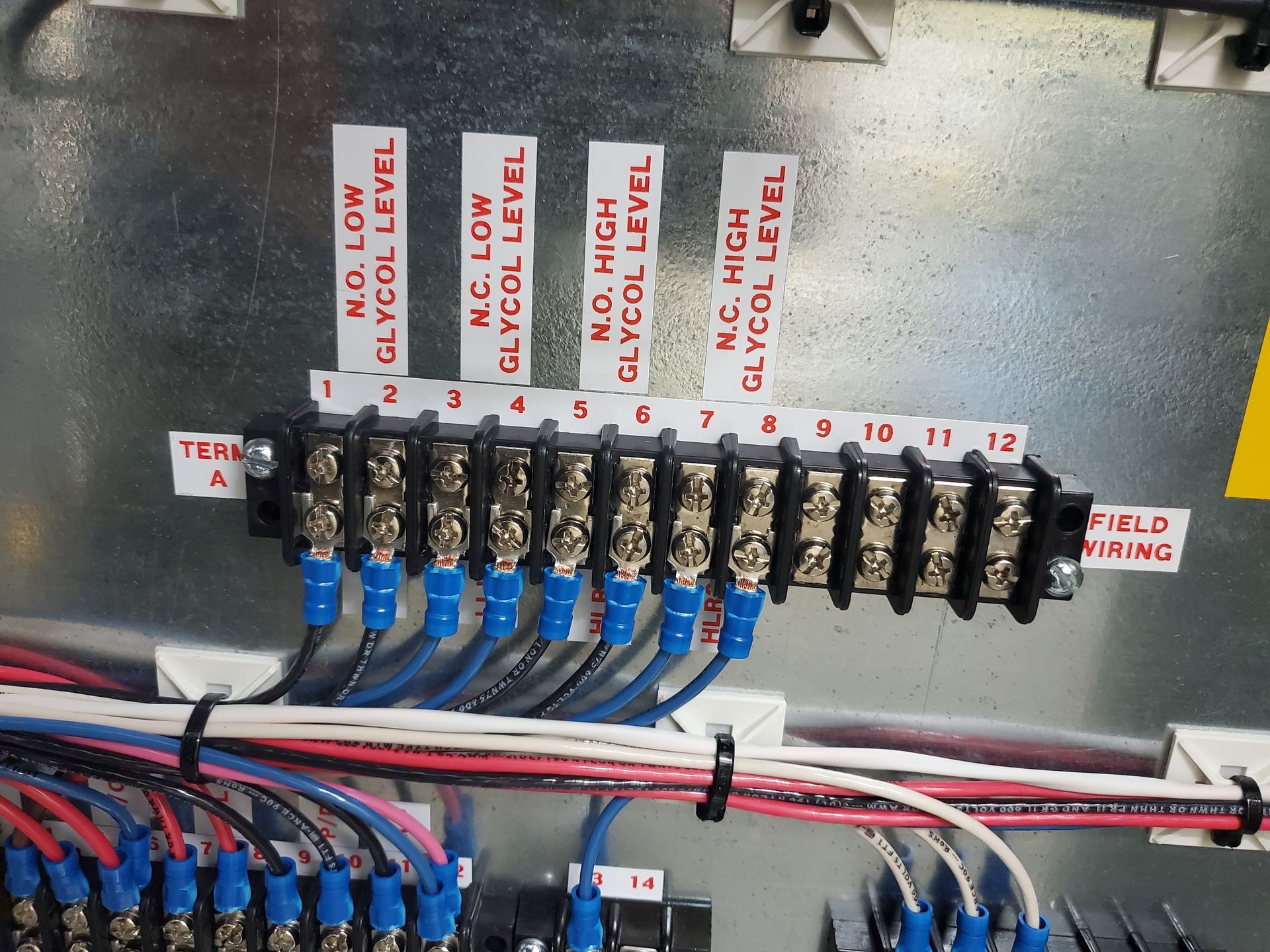A bunch of wires are connected to a terminal block with labels that say m.c. high glycol level