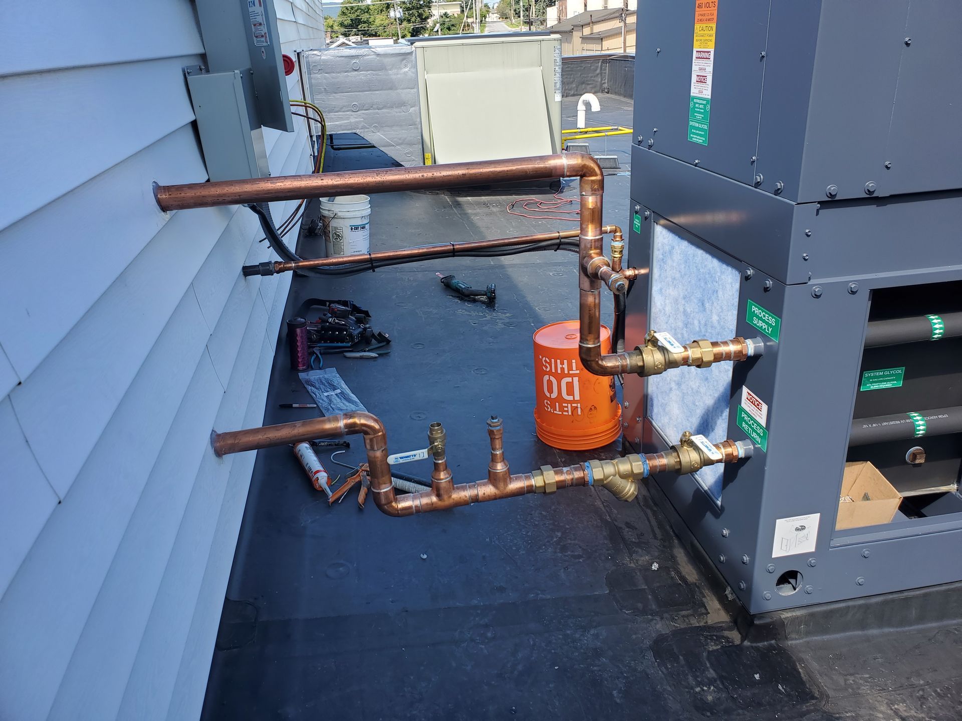 Copper pipes are being installed on the side of a building.