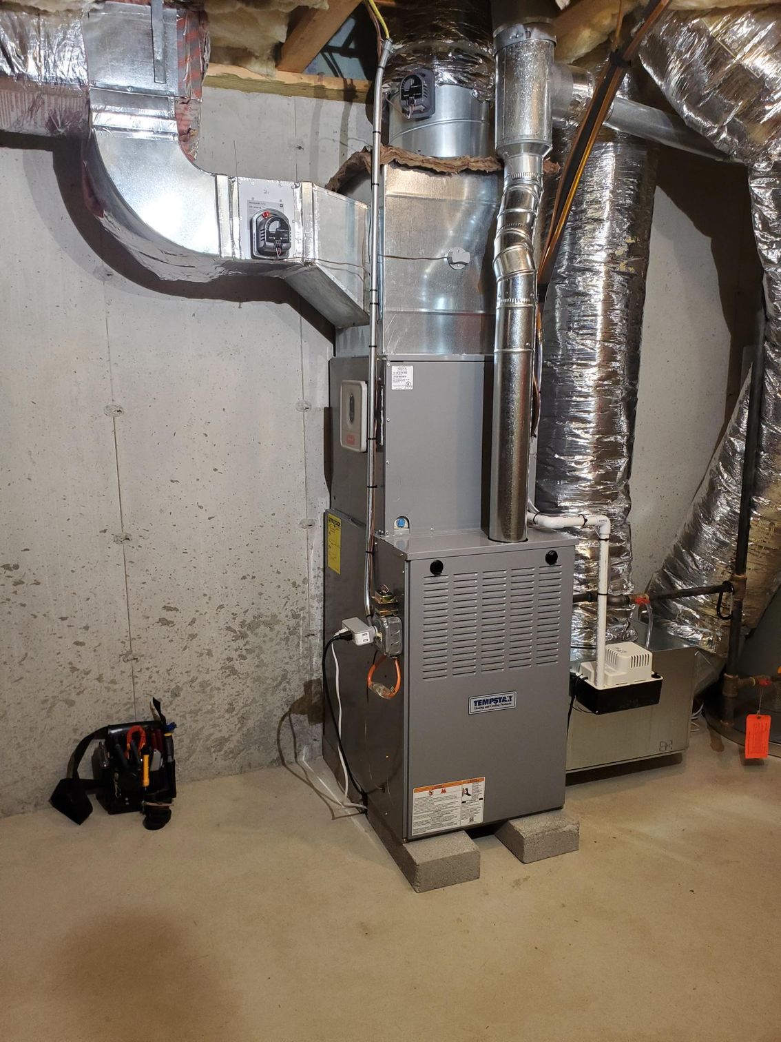 A heating and cooling system is installed in a basement.