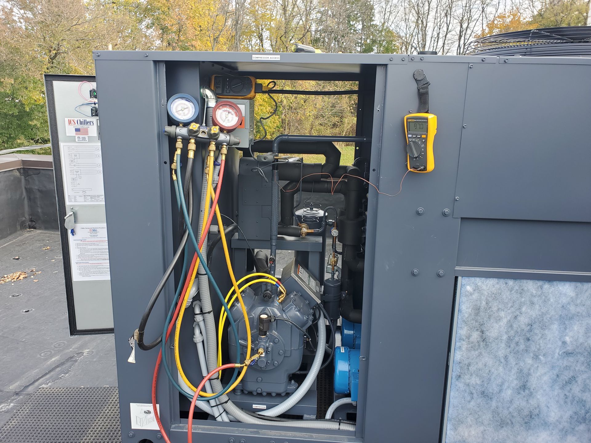 A machine with its doors open and a bunch of wires coming out of it.