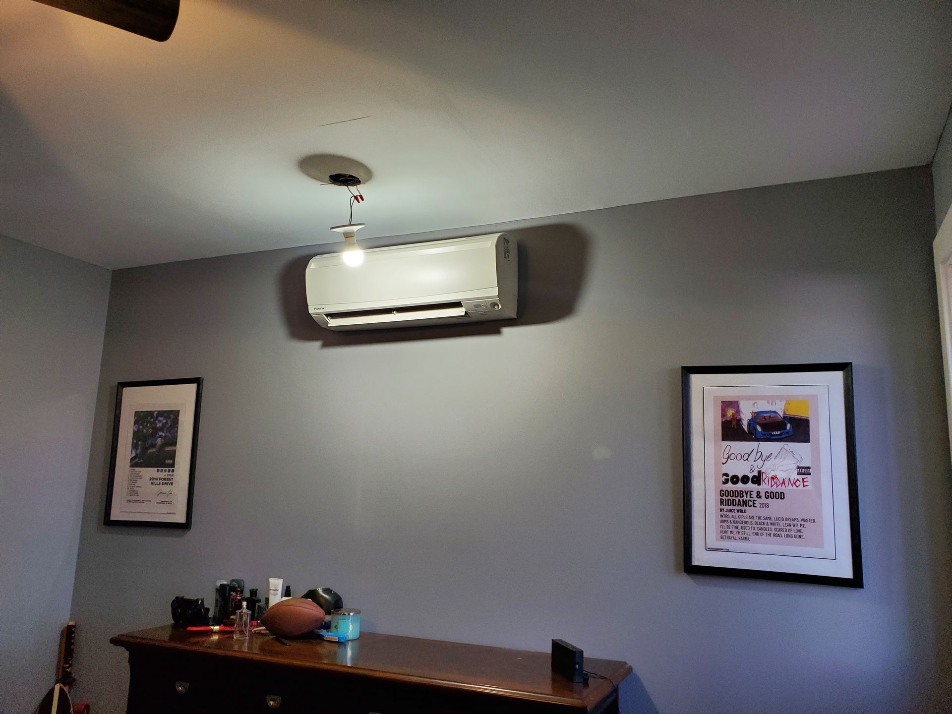 A room with a ceiling fan and a picture on the wall.