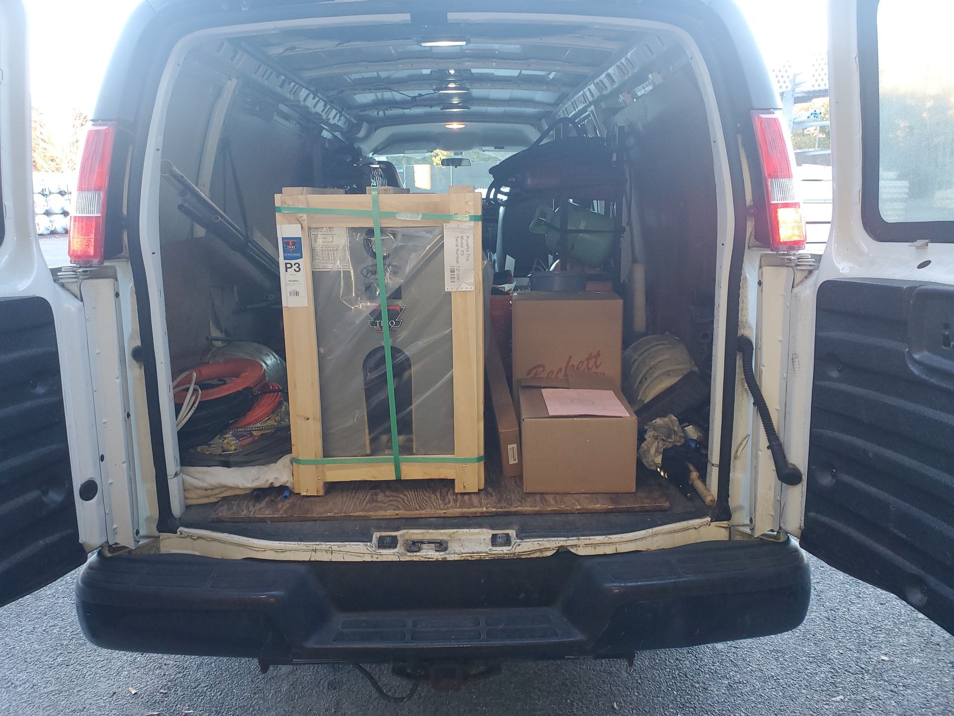 The back of a van is filled with boxes and a machine.